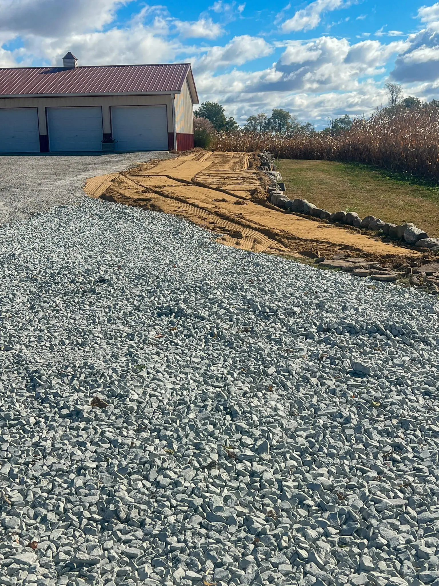Gravel drive and drainage bed taking shape beside a pole barn